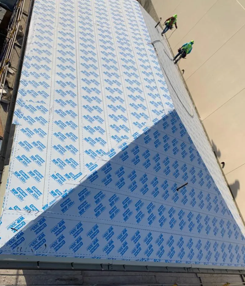 Professional roofers installing underlayment on a metal roof in Little Canada